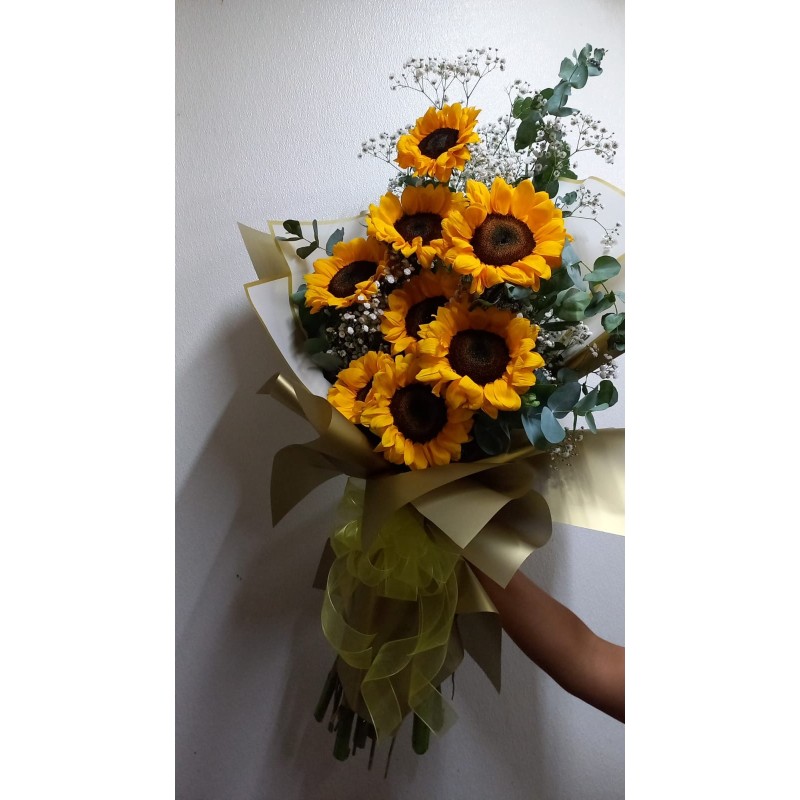 Ramo de girasoles con envoltura dorada y moño amarillo