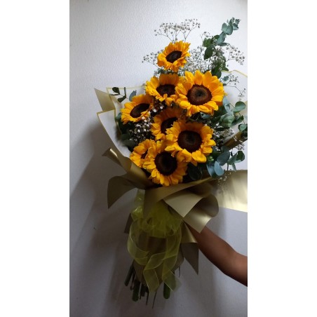 Ramo de girasoles con envoltura dorada y moño amarillo